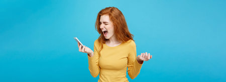 Lifestyle and Technology concept - Portrait of ginger red hair girl shouting on the phone. Isolated...