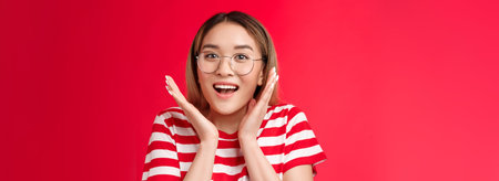 Surprised happy cheering cute asian blond girl realize got lucky smiling broadly, gesturing shaking...