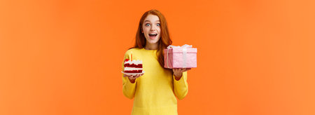 Surprised happy and amused cheerful redhead b-day girl celebrating her birthday receive presents and...