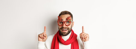 Christmas, New Year and celebration concept. Close-up of excited bearded guy in party glasses,...
