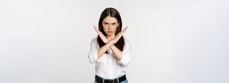 Serious woman showing stop sign, disagree, rejecting smth bad, standing over white background