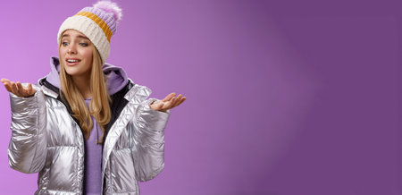 Delighted caring lovely young blond woman looking snowflake drop palm glancing hand tenderly smiling cherish nice moment enjoying winter snowy day standing pleased purple backgroundの写真素材