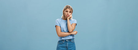 Studio shot of displeased moody girlfriend feeling disappointed boyfriend spoilt date leaning head...