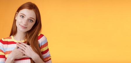 Lovely silly cute redhead young european girl tilting head look gently smiling tender camera press...