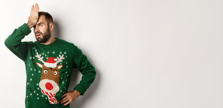 New Year, holidays and celebration. Annoyed young bearded man slap his forehead, facepalm irritated or tired, standing over white backgroundの写真素材