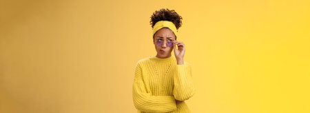 Perplexed unsure stylish african-american female creative designer in headband sweater sunglasses...