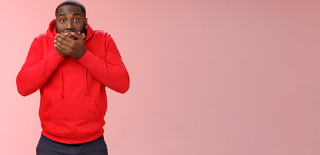 Shocked gasping surprised african-american guy overhear stunning rumour press palms mouth not slip word widen eyes impressed stunned unbeliavable amazing gossip, standing pink backgroundの写真素材