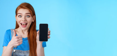 Amazed fascinated cute redhead woman recommend good smartphone, awesome new app, phone game, show...