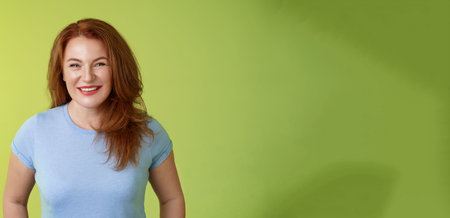 Cheerful kind happy redhead middle-aged mother look caring delighted smiling broadly gaze admiration...