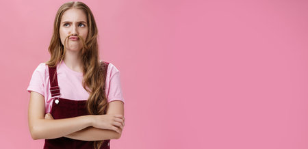 Portrait of cute funny and charismatic girl making moustache from hair and silly face fooling around...