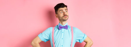 Funny caucasian man with moustache and bow-tie, standing confident with hands spread sideways,...