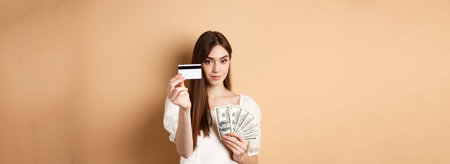 Young woman showing plastic credit card, prefer contactless payment instead of dollar bills,...