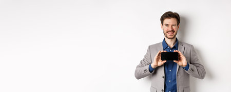 E-commerce and online shopping concept. Cheeky male model in suit winking and showing empty...