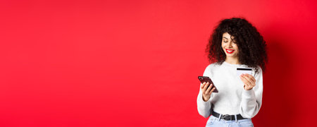 E-commerce and online shopping concept. Attractive caucasian woman paying for purchase in internet,...
