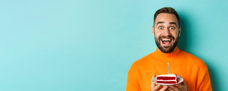 Close-up of happy adult man celebrating birthday, holding bday cake with candle and making wish,...