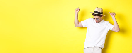 Tourism, travelling and holidays concept. Man tourist enjoying vacation, dancing in straw hat and...