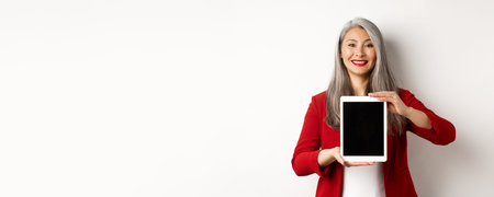 Business. Proud asian female manager showing blank digital tablet screen, smiling and demonstrating...