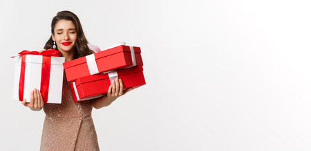 Holidays, celebration concept. Beautiful caucasian woman in elegant dress holding Christmas presents...