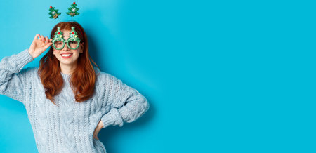 Winter holidays and Christmas sales concept. Beautiful redhead female model celebrating New Year,...