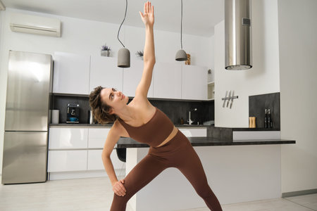Stay healthy and fit. Beautiful young asian woman in sportswear doing yoga while relaxing at home