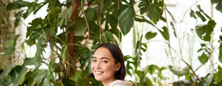 Young female entrepreneur, girl sits with laptop in cafe, works on remore from restaurant, drinks coffee and smilesの写真素材