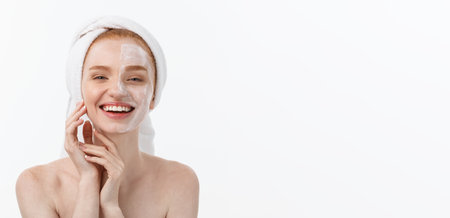 beautiful model applying cosmetic cream treatment on her face on white.の写真素材