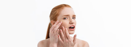 Young caucsian woman squeezes acne on the face of beautyの写真素材