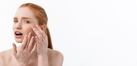 Young caucsian woman squeezes acne on the face of beautyの写真素材