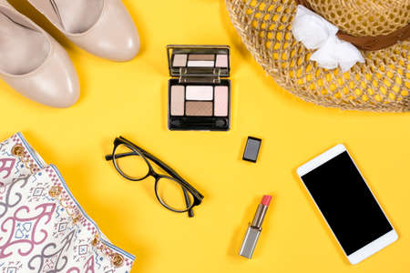 Arrangement of essential woman summer accessories on bright yellow backgroundの写真素材