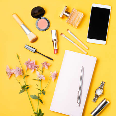 Modern woman accessories. Beauty products, smartphone, note book, accessories on a pastel backgroundの写真素材