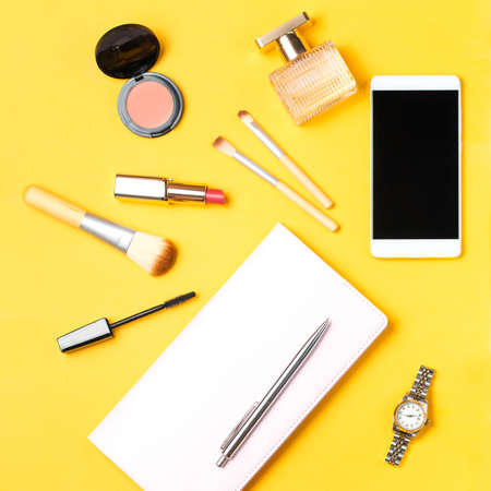 Modern woman accessories. Beauty products, smartphone, note book, accessories on a pastel backgroundの写真素材