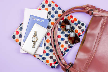 Travel concept - woman fashion accessories, wristwatch, spotted scarf, sunglasses, passport, note pad, smartphoneの写真素材