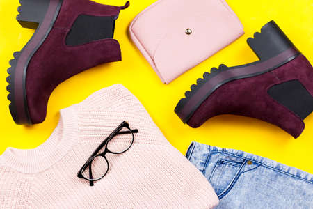 Autumn female clothing - pink sweater, blue jeans, leather handbag, chunky ankle boots, accessoriesの写真素材