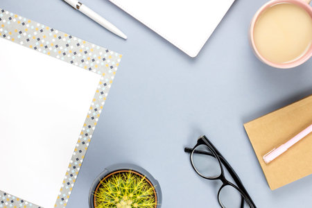 Flat lay home office desk. Female workspace with planner, eyeglasses, tea mug, diary, plant. Copy...