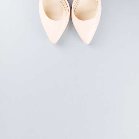 Pale pink female shoes close up on gray background.の写真素材