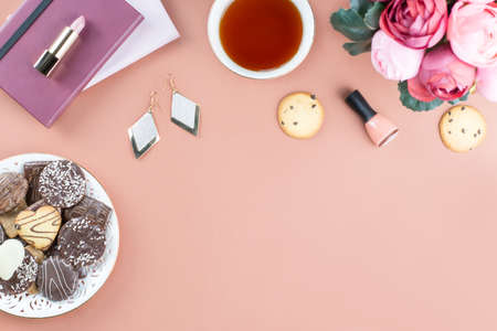Flat lay home office desk. Feminine workspace with diary, flowers, sweets, fashion accessories. Fashion blogger concept.の写真素材