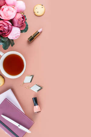 Flat lay home office desk. Feminine workspace with diary, flowers, sweets, fashion accessories. Fashion blogger concept.の写真素材