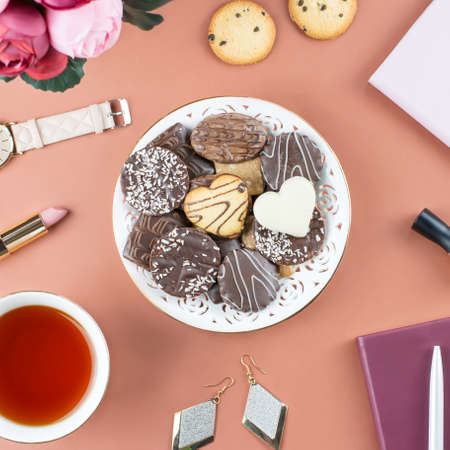 Flat lay home office desk. Feminine workspace with diary, flowers, sweets, fashion accessories. Fashion blogger concept.の写真素材