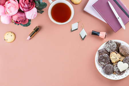 Flat lay home office desk. Feminine workspace with diary, flowers, sweets, fashion accessories. Fashion blogger concept.の写真素材