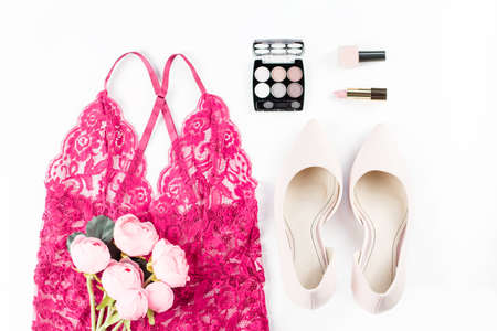 Woman red lace lingerie, flowers, pumps and cosmetics on white background.の写真素材