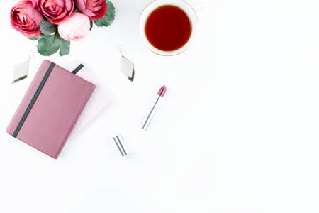 Flat lay home office desk. Feminine workspace with diary, flowers, sweets, fashion accessories. Fashion blogger concept.の写真素材