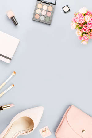 Fashion blogger workspace flat lay with pumps, cosmetics, purse, planner book and flowers.の写真素材