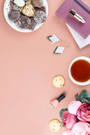 Flat lay home office desk. Feminine workspace with diary, flowers, sweets, fashion accessories. Fashion blogger concept.の写真素材