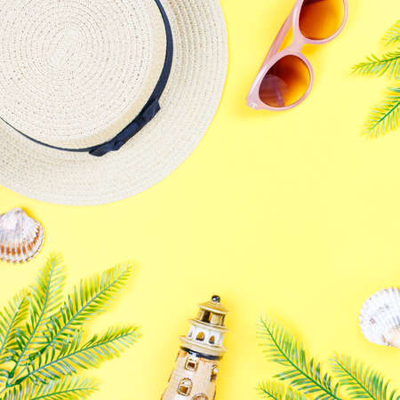 Tropical summer concept with woman fashion accessories, leaves and pineapple on yellow background. Flat lay, top viewの写真素材