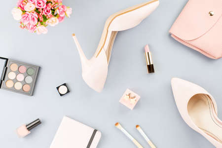 Fashion blogger workspace flat lay with pumps, cosmetics, purse, planner book and flowers.の写真素材