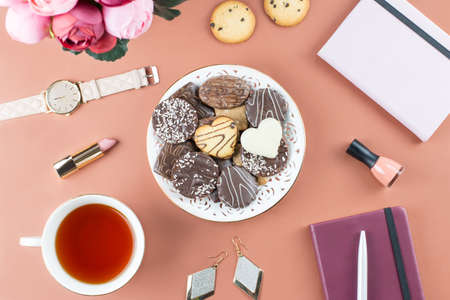 Flat lay home office desk. Feminine workspace with diary, flowers, sweets, fashion accessories. Fashion blogger concept.の写真素材