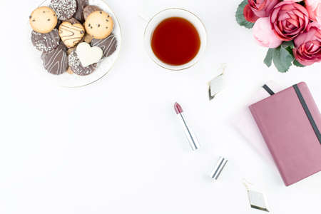Flat lay home office desk. Feminine workspace with diary, flowers, sweets, fashion accessories. Fashion blogger concept.の写真素材