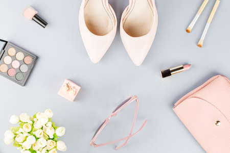 Fashion blogger workspace flat lay with pumps, cosmetics, purse, planner book and flowers.の写真素材
