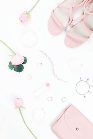 Fashion blogger workspace flat lay with sandals, jewelry, cosmetics, purse and flowers.の写真素材