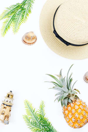 Tropical summer concept with woman fashion accessories, leaves and pineapple on white background. Flat lay, top viewの写真素材